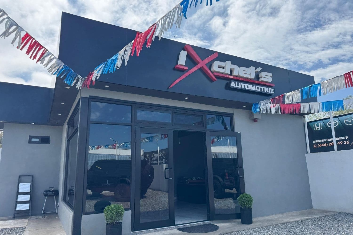Fachada de la oficina de Ixchel's Automotriz en Ensenada, con su letrero y banderines de colores